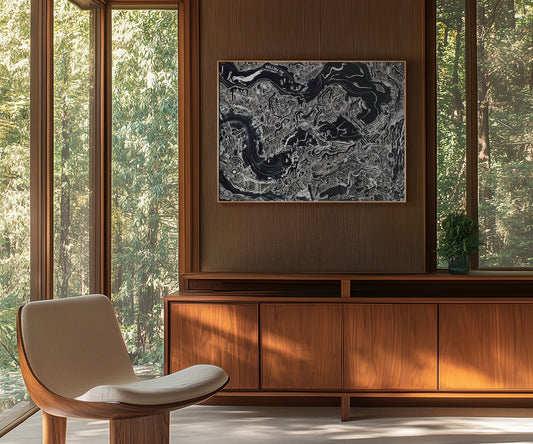 Large black abstract artwork hanging above a wooden cabinet in a modern living space.
