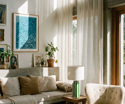 Framed blue abstract artwork hanging on a living room gallery wall above a sofa.