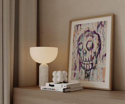 Framed abstract skull art print styled on a wooden cabinet with modern decor.
