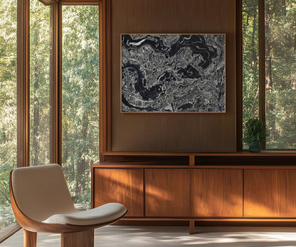 Large black abstract artwork hanging above a wooden cabinet in a modern living space.