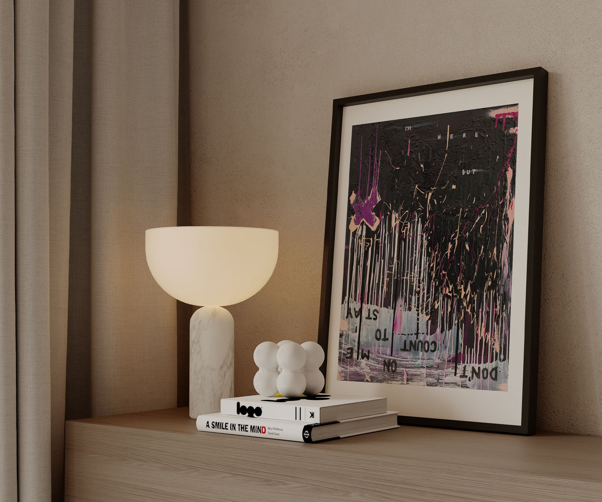 Framed black abstract wall art print with pink and gold details by The Jana Saga styled on a wooden cabinet.