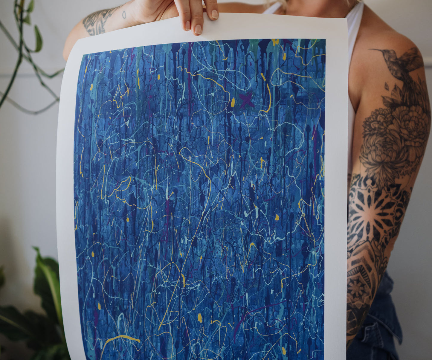 Person holding a blue abstract wall art print by The Jana Saga showing textured paint details.